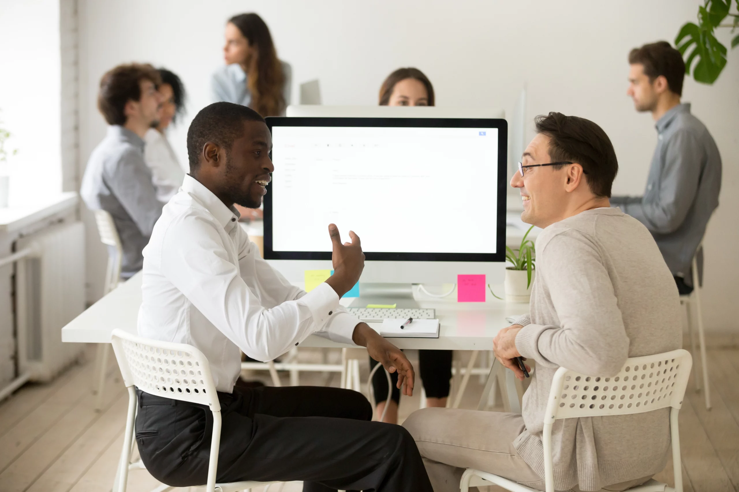 accompagnement-numerique-formation-ateliers Deux hommes échangent assis à un bureau