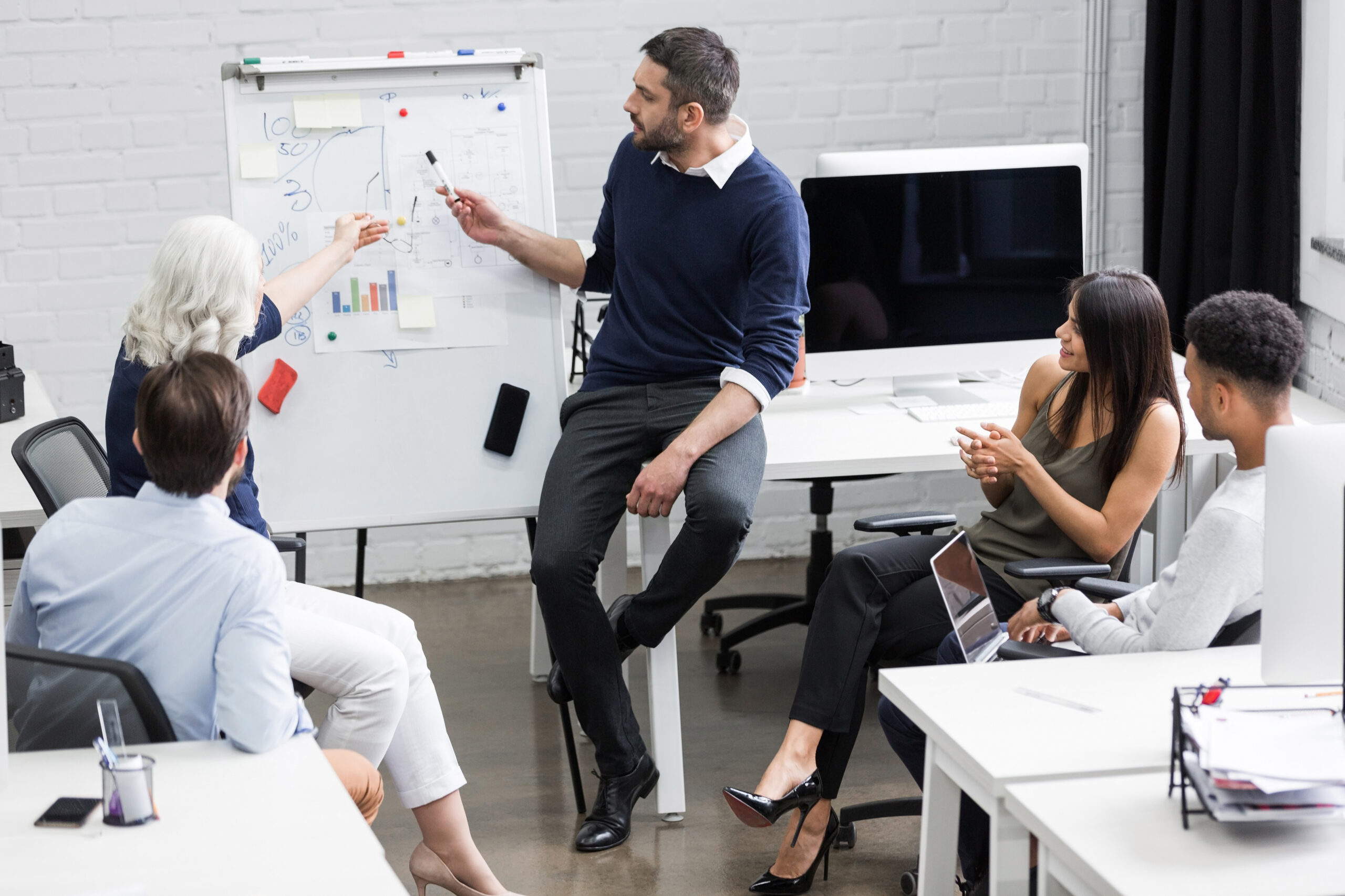 Creative people sitting at table in boardroom un formateur devant un groupe d'apprenants